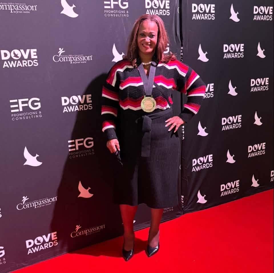 Dr. Sctonda Kelly Gordon wearing a gold medal on the red carpet at the Dove Awards